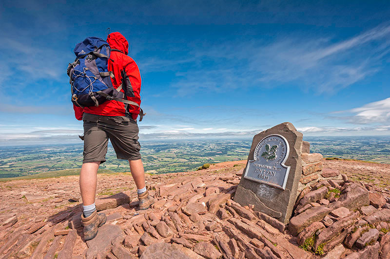 Male walker at trig point on summit of Pen y Fan Brecon Beacons Powys South Walking Activities and Sports
